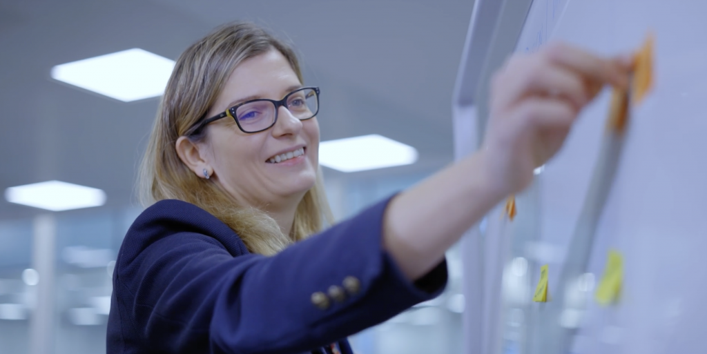 Colleague adding information onto a whiteboard