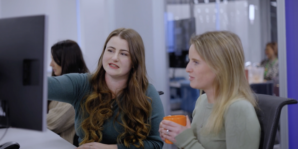 Two female colleagues sharing a computer screen