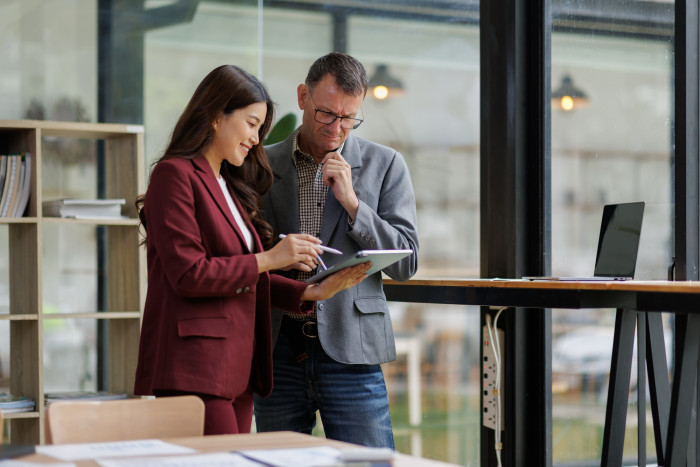 Colleagues_in_jackets_standing_at_laptop.jpg