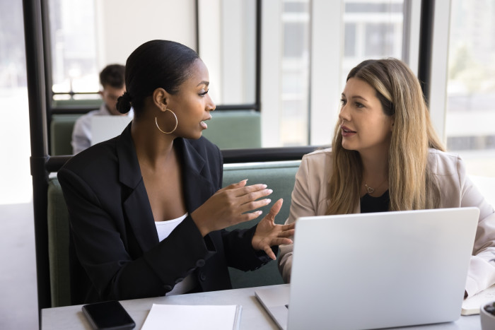 Female_colleagues_at_laptop_chatting.jpg