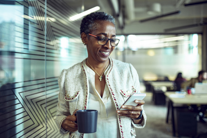 Colleague smiling at phone in the office