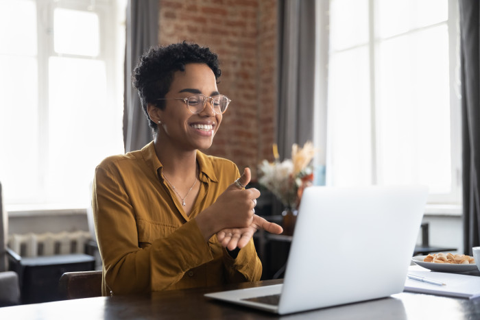 Colleague giving a thumbs-up to her laptop