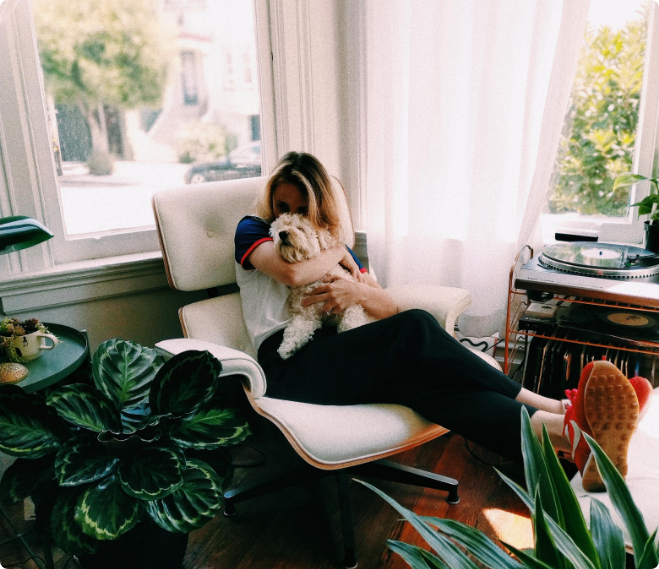 Woman cuddling her dog at home