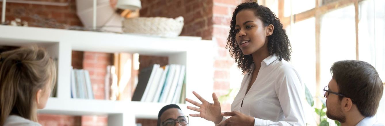 Colleague speaking in front of book shelves