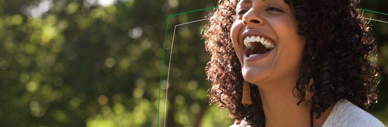 Woman smiling outdoors by trees