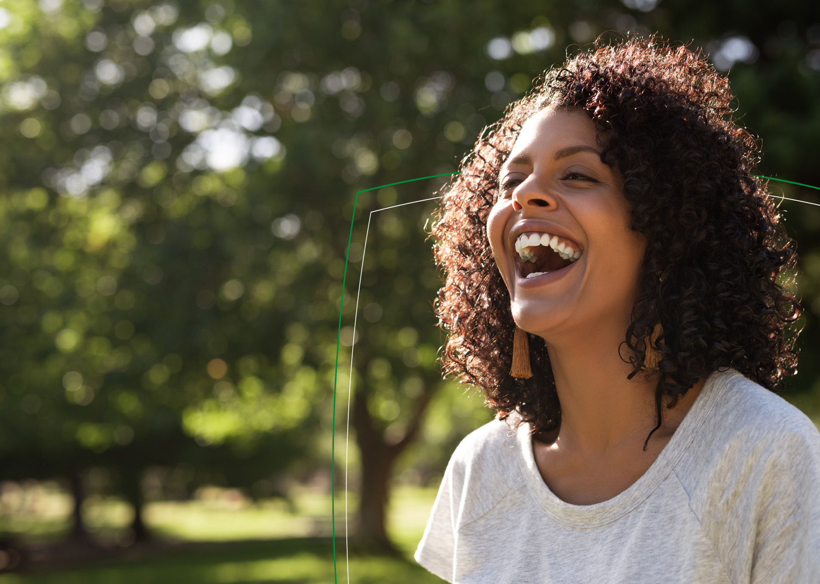 Woman smiling outdoors by trees